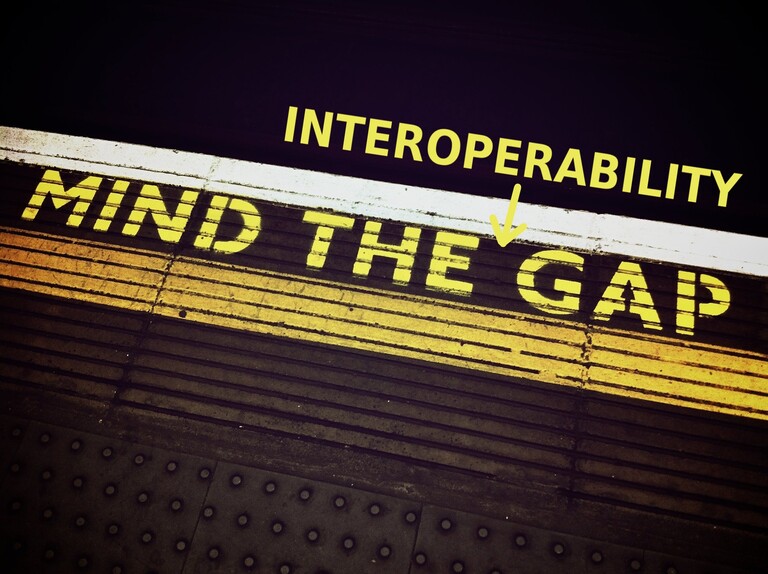 Train platform with "Mind the Interoperability Gap" written in yellow
