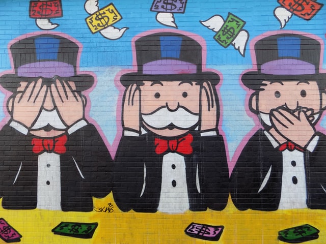 Mural of the Monopoly man mimicking "see no evil, hear no evil, speak no evil"