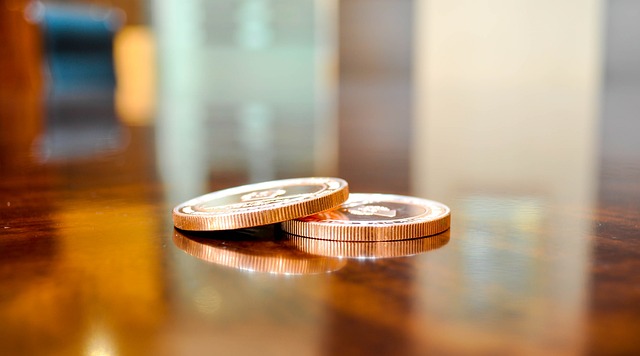 Two coins partially stacked on a brown table